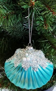 an ornament hanging from a christmas tree in the shape of a seashell