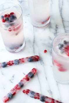 two glasses filled with ice and berries next to each other