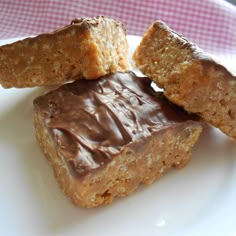 three pieces of chocolate peanut butter bars on a white plate