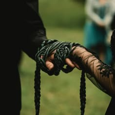 two people holding hands with black lace on them