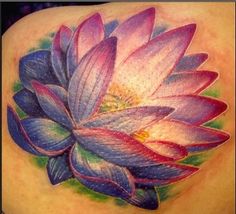 a woman's back tattoo with a purple flower on it