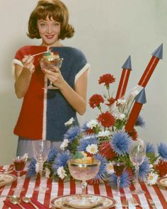 a woman standing in front of a table with red, white and blue decorations