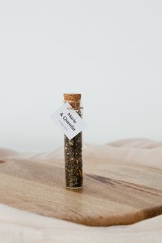 a bottle filled with lots of spices sitting on top of a wooden table