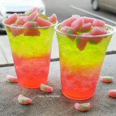 two cups filled with candy sitting next to each other