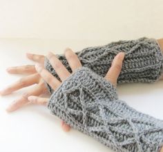 two hands wearing knitted gloves on top of a table