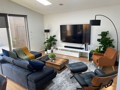 a living room filled with furniture and a flat screen tv mounted to the side of a wall