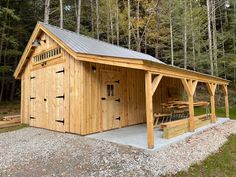 a wooden building with a metal roof in the woods