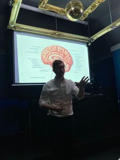 a man standing in front of a projector screen