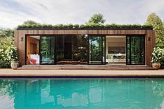 a pool house sitting next to a lush green forest