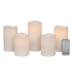 five lit candles with remote control on white background