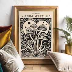 a framed poster on the wall above a couch with pillows and plants in vases