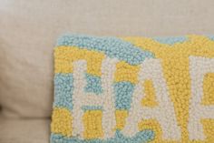 a close up of a pillow on a couch with the word fall spelled in white letters