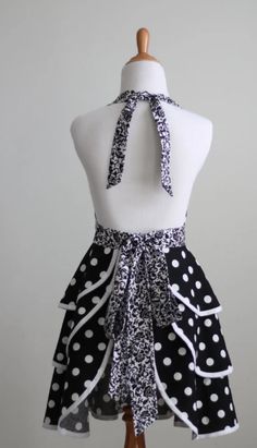 a mannequin wearing a black and white dress with polka dots on the skirt