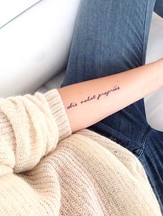 a woman with a tattoo on her arm that says, this tattoo reminds my feelings