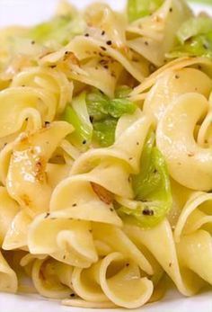 pasta with broccoli and other vegetables on a white plate, ready to be eaten