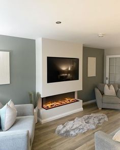 a living room with two couches and a flat screen tv mounted on the wall