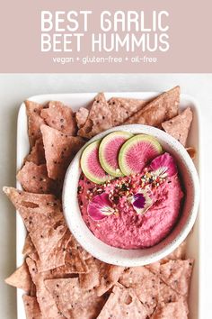 a white plate topped with guacamole and sliced watermelon slices next to tortilla chips