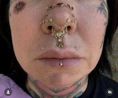 a close up of a person with piercings on their nose