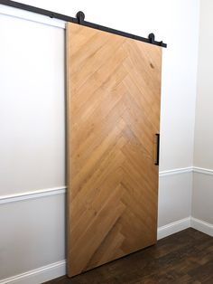 an empty room with a wooden door and hard wood flooring on the side wall