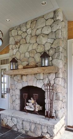 a stone fireplace with lanterns on the mantle