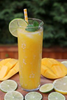 a tall glass filled with orange juice and lime