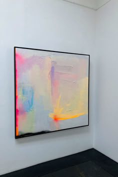 an abstract painting hangs on the wall next to a black floor