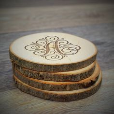 four wooden coasters stacked on top of each other with a monogrammed design