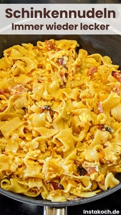 a skillet filled with pasta and meats on top of a stove burner