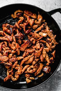 chicken is cooking in a skillet on the stove top, ready to be cooked