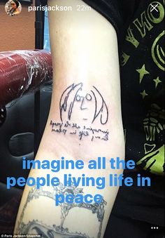 a person with a tattoo on their arm saying imagine all the people living life in peace