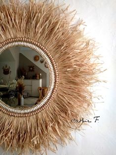 a mirror that is on the wall with some grass around it and a table in the background