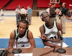 two men sitting at a table with headphones on