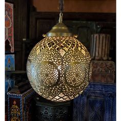 an ornately designed lamp hanging from the ceiling in a room filled with other decorative items