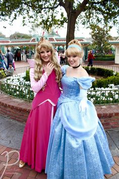 two women dressed as princesses standing next to each other