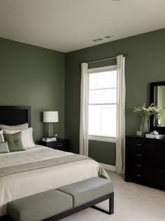 a large bedroom with green walls and white carpeted flooring is pictured in this image