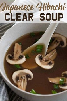 a white bowl filled with soup and mushrooms on top of a striped table cloth next to a spoon