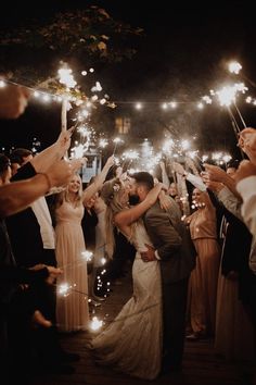 a bride and groom kissing while surrounded by sparklers