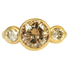 three stone ring in yellow gold with two diamonds on each side and one diamond at the top