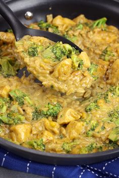 broccoli and chicken are being cooked in a skillet with a blue towel