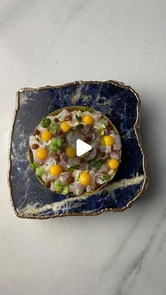 a blue plate topped with food on top of a white tablecloth covered floor next to a wall