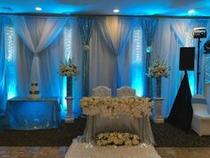 an elegant wedding setup with white flowers and blue lighting