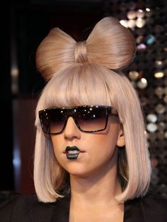 a woman wearing sunglasses and a fake head with a bow on it's head