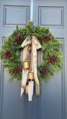 a christmas wreath with bells and pine cones hanging on the front door to welcome guests