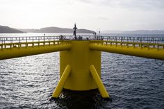 a yellow bridge over the water with people on it