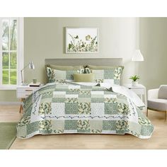 a bed with green and white bedspread in a bedroom next to a window