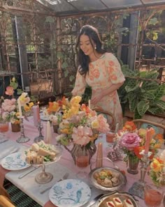 a woman standing in front of a table filled with food