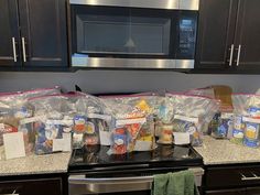 the kitchen counter is covered with plastic bags full of food, including condiments and seasonings