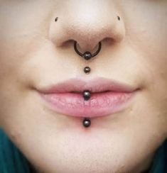 the nose has two balls attached to it's nose and is wearing a nose ring