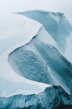 an iceberg that is partially submerged in the water and has snow on it's sides