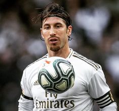 a soccer player is holding a ball in his hand